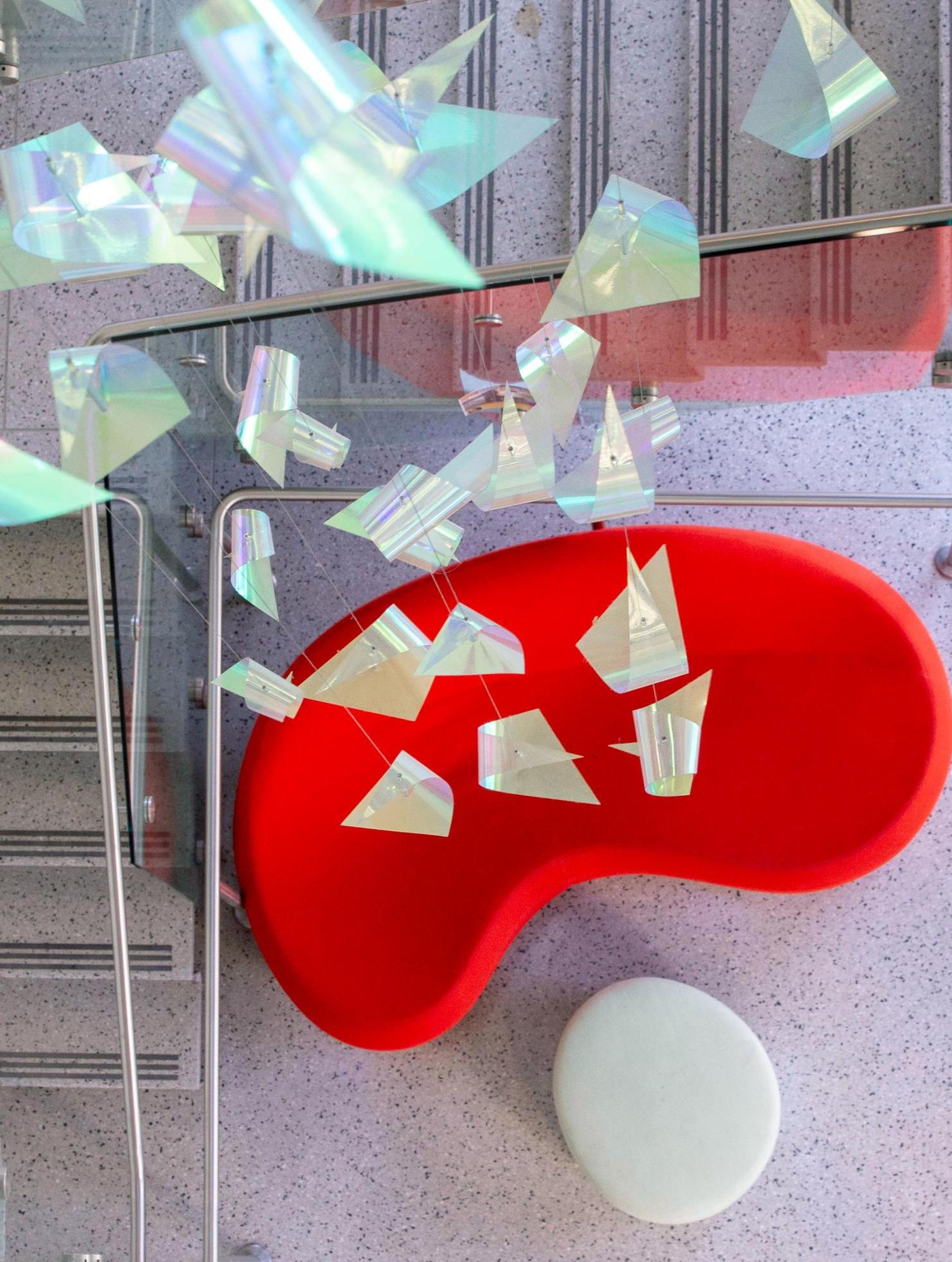 overhead view of a red sofa at the bottom of a glass enclosed staircase