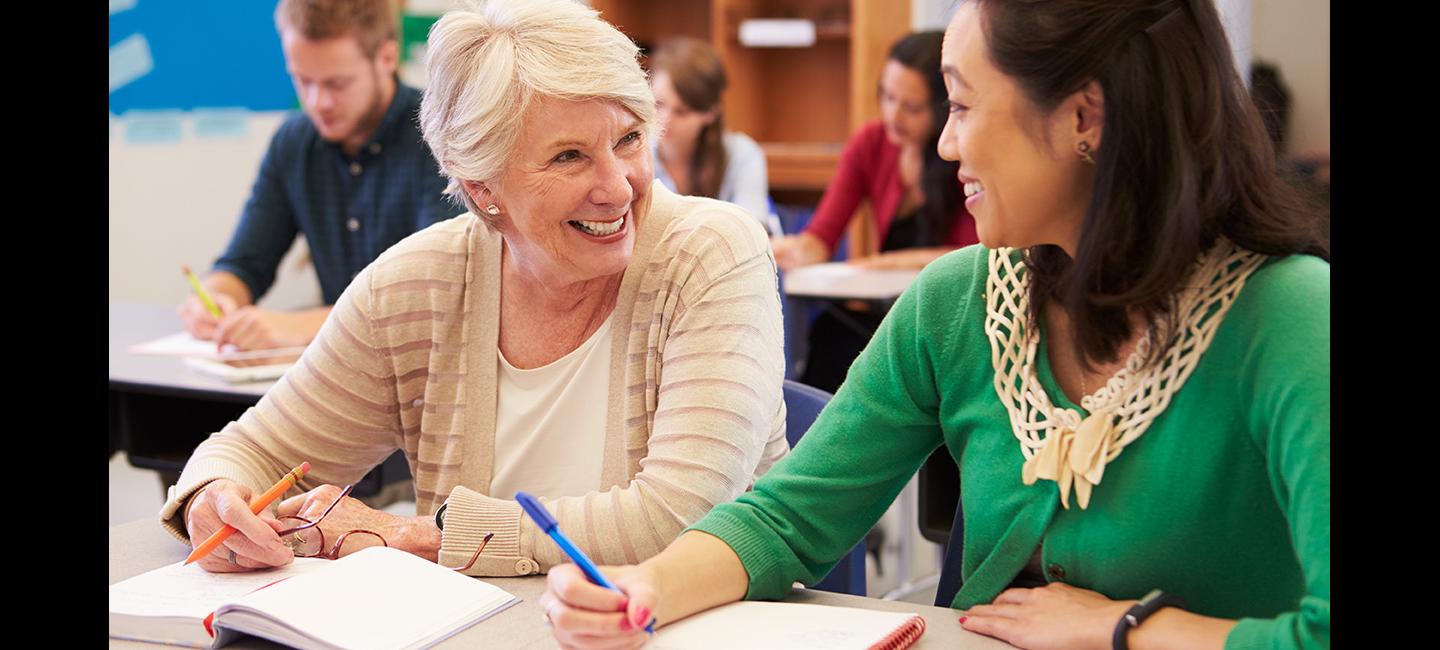 Adults attending class, with two students smiling at each other