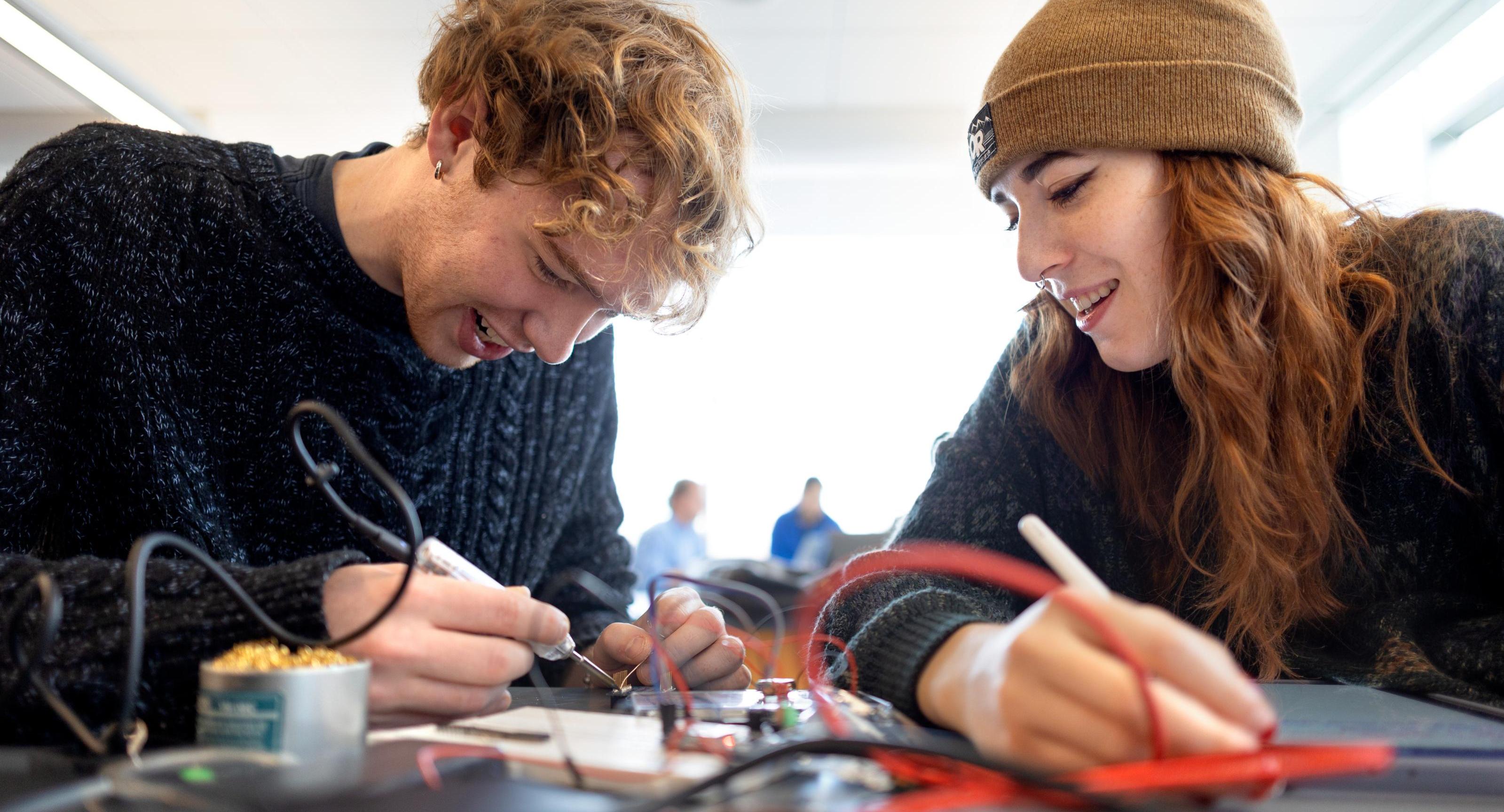 two college students working on wiring
