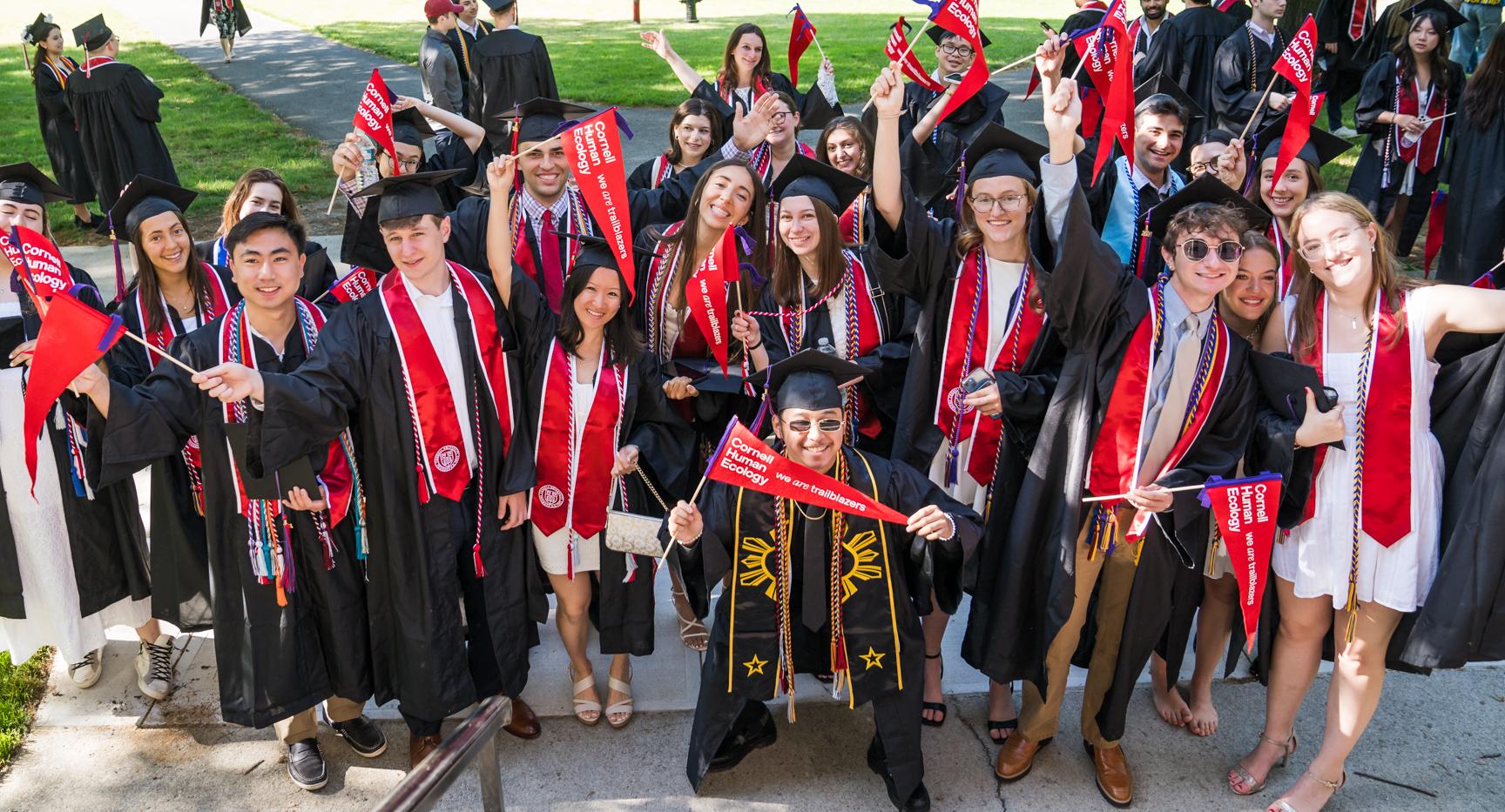 large group of students wave pennants at Cornell commencement