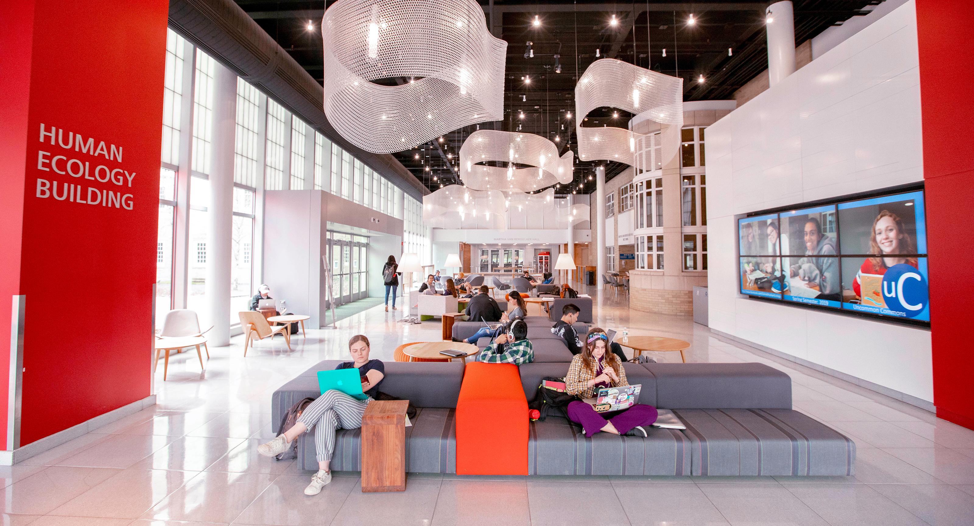 big, open, modern room in a college with students lounging on low couches