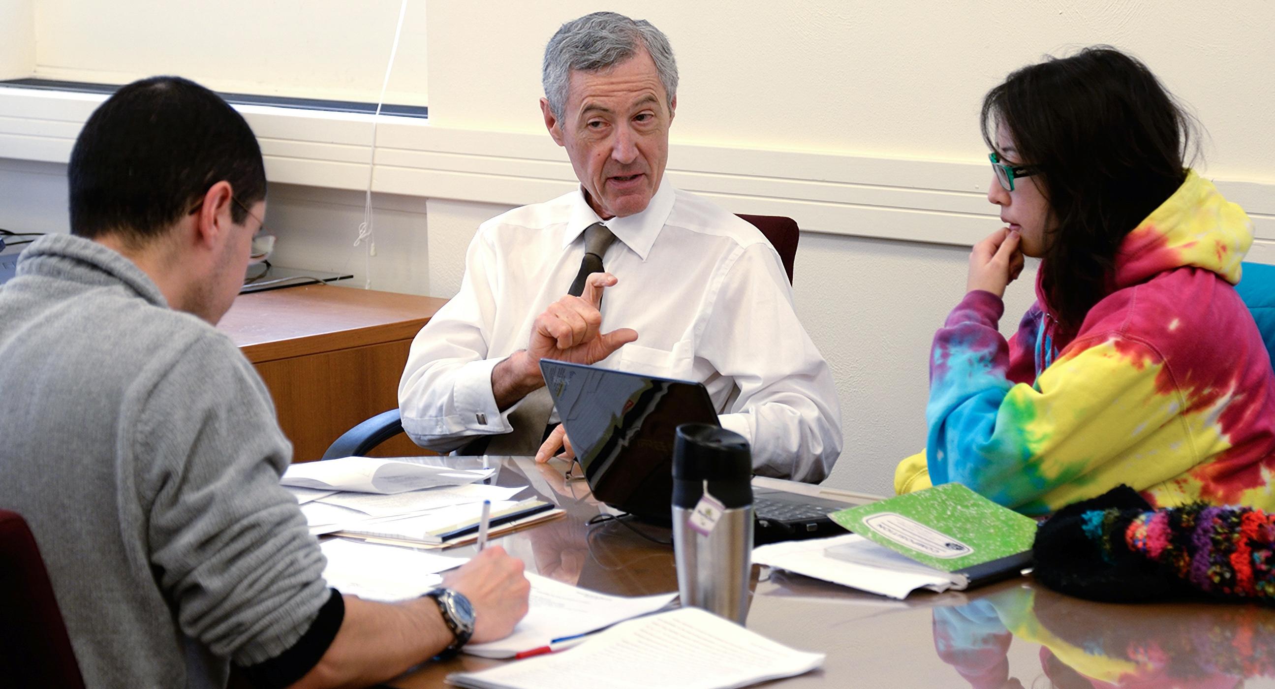 professor speaking with college students in class