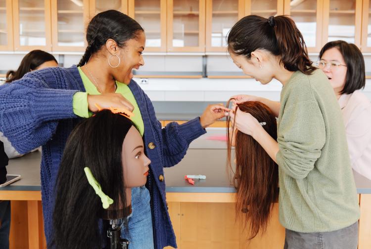 Lauren helps Melody with her braiding 
