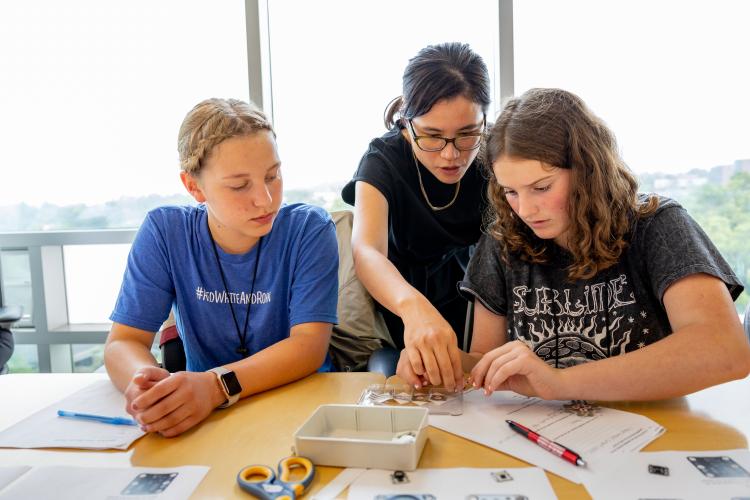 Cindy Kao helps two students during a 4-H workshop 