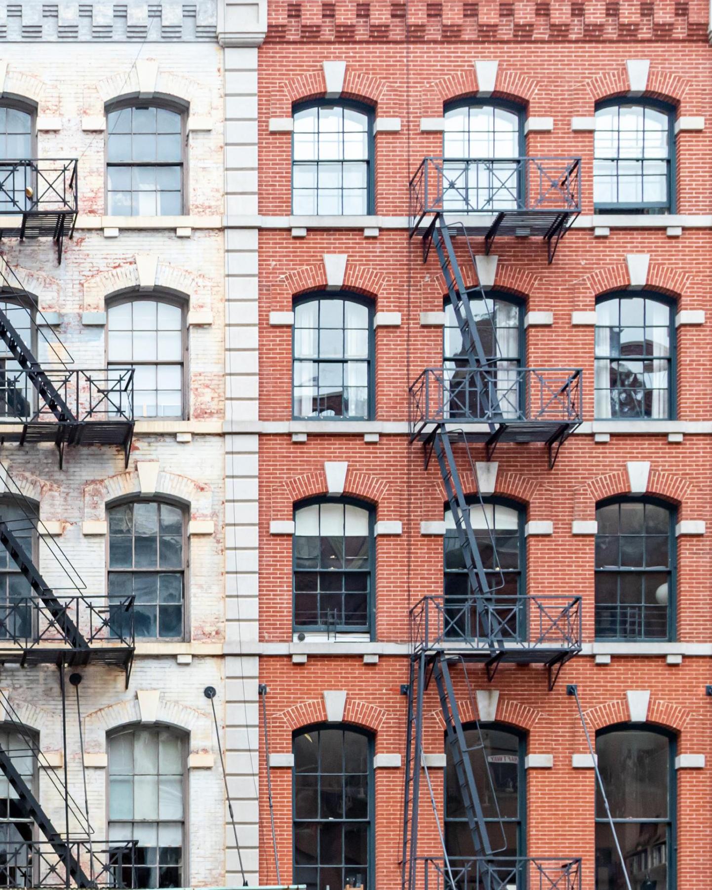brick facades of city buildings with fire escapes