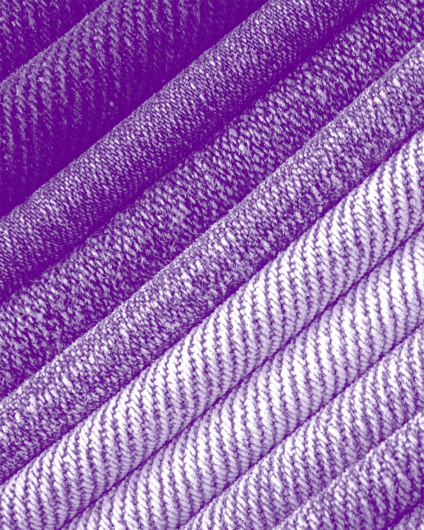 purple tinted close up of a stack of denim