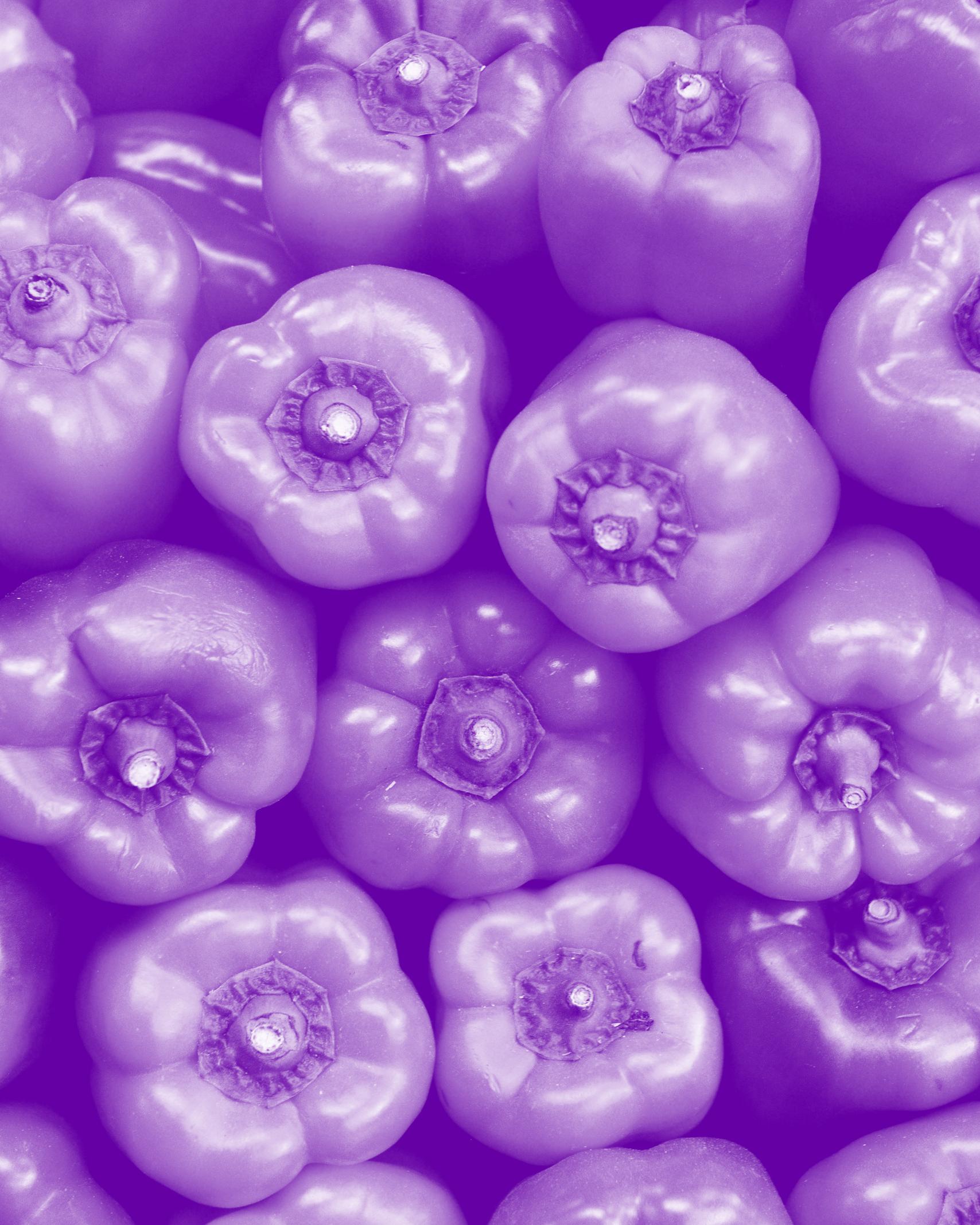 Stack of red bell peppers with a purple hugh