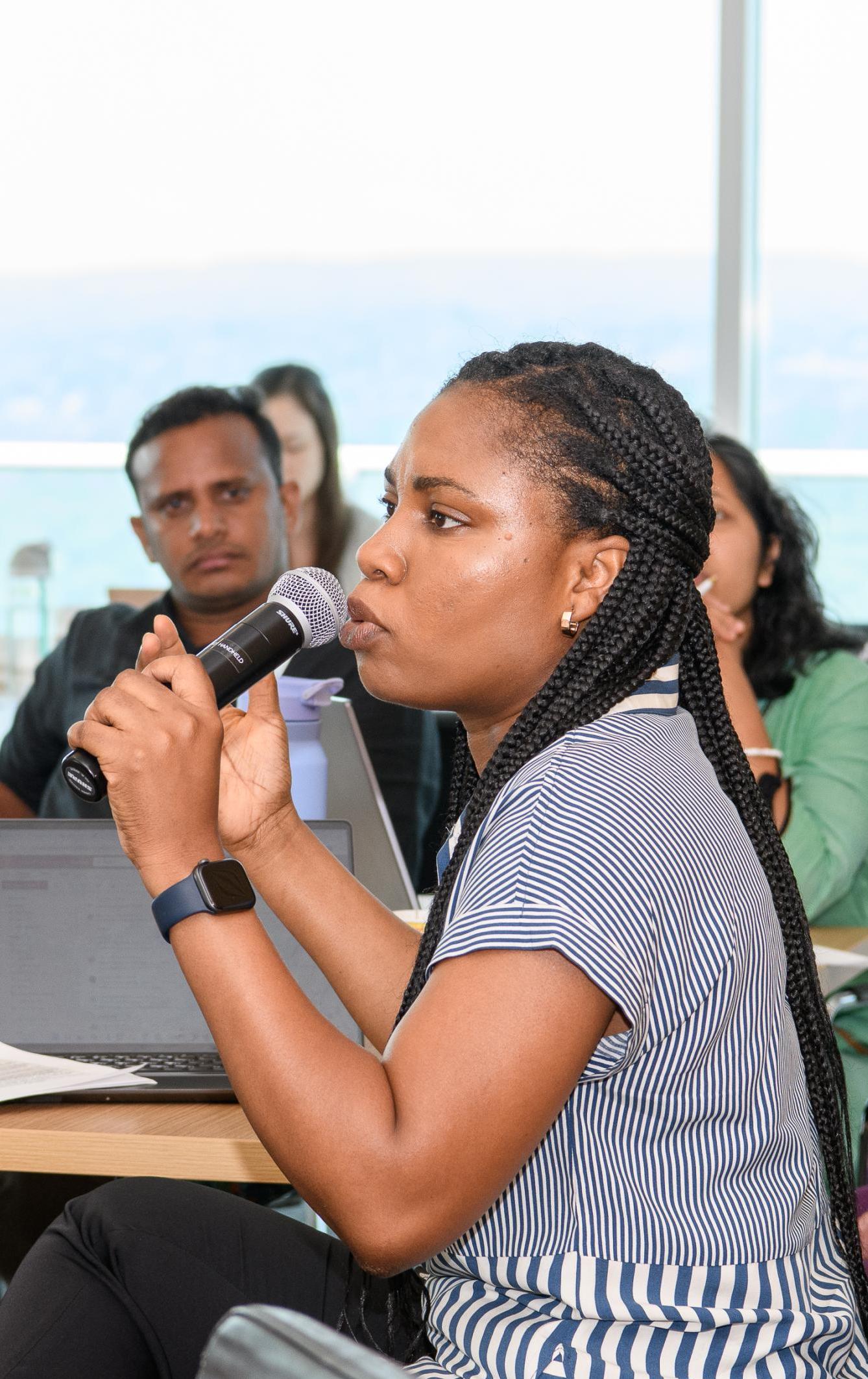 A woman speaks to a group using a microphone