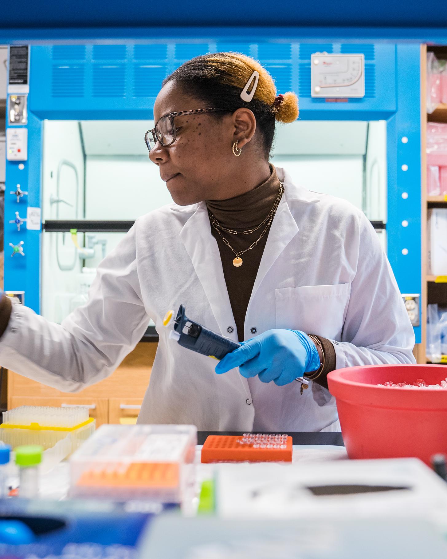 student in a lab coat working in a lab