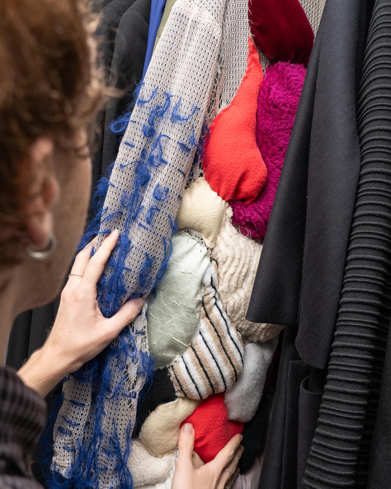 fashion student looking through a rack of clothes