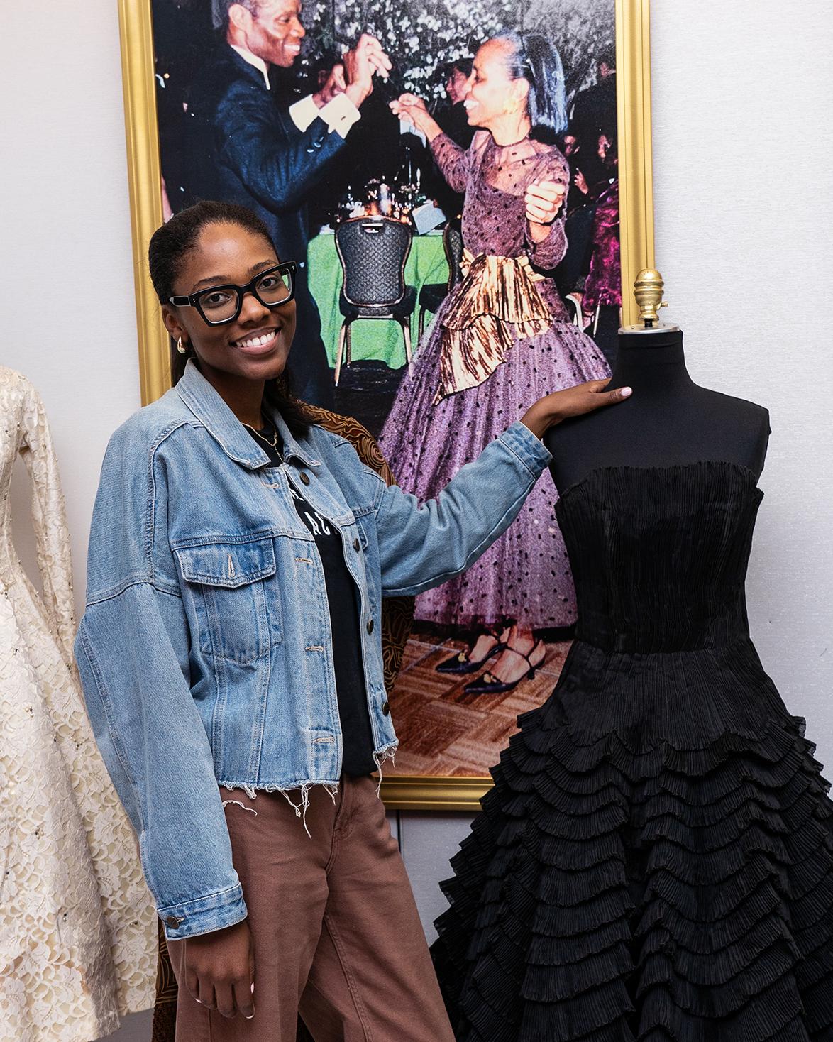 graduate student standing with a mannequin in a fashion display