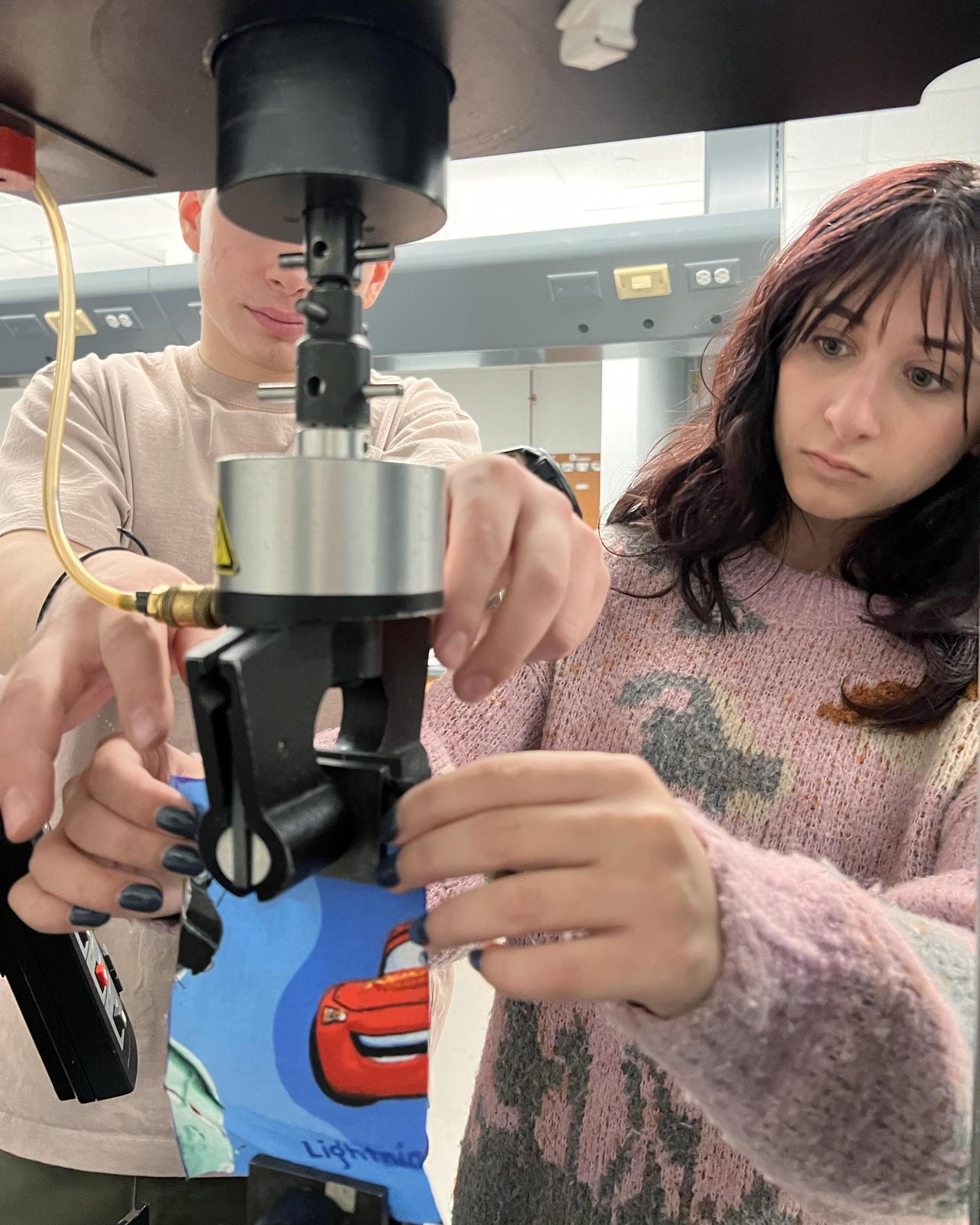 two college students testing fabric strength