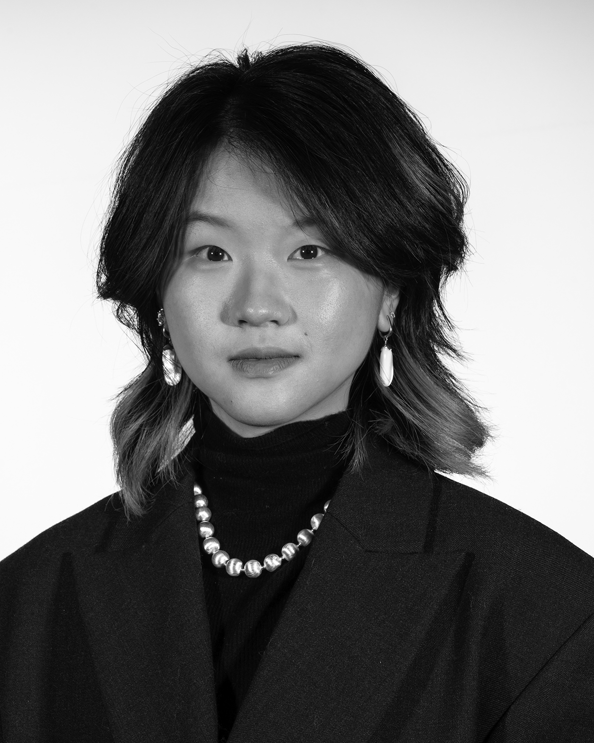 portrait of a person wearing a dark blazer and necklace 