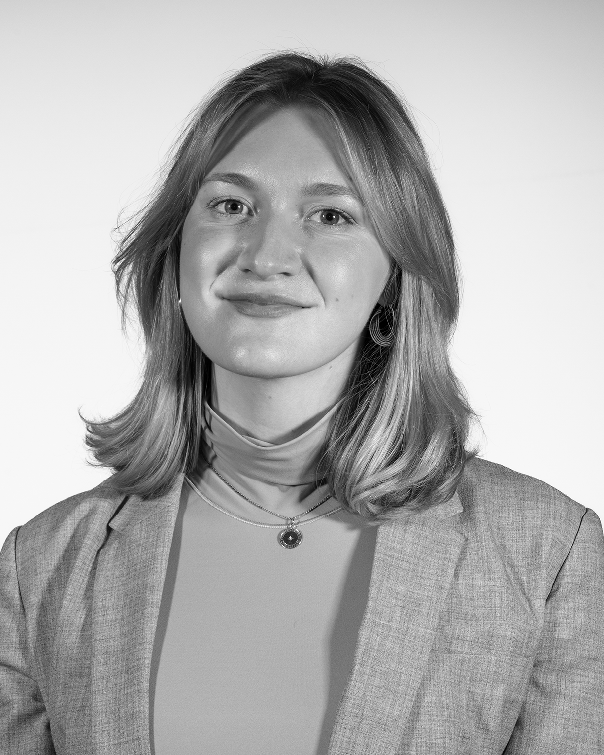 portrait of a person with blonde hair wearing a blazer