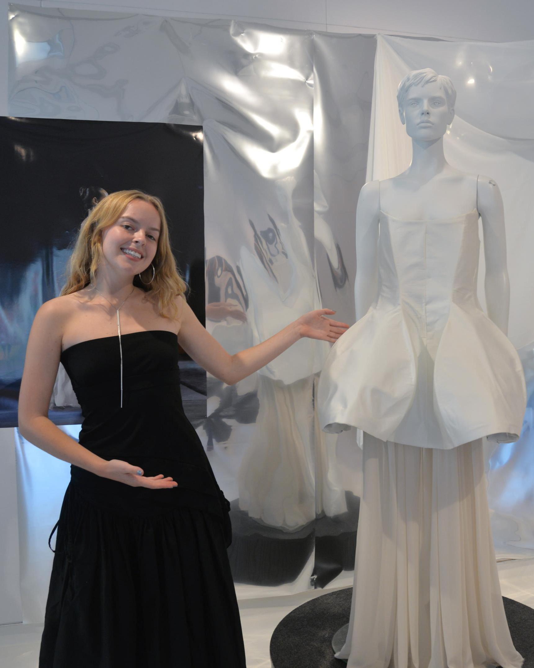 Roan Harvey poses with the white gown she designed