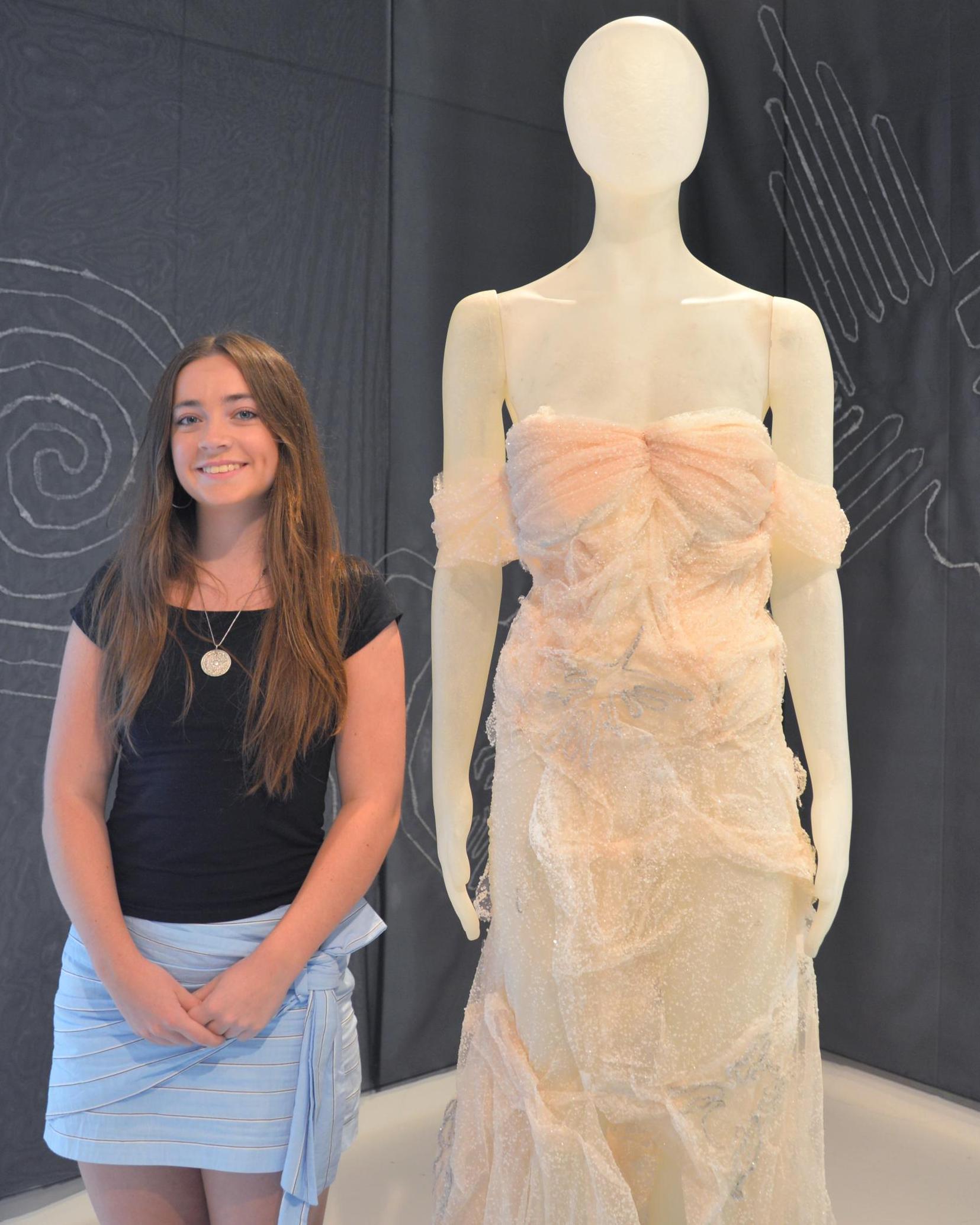 Margaret Watkins poses next to her dress which she hand crystallized