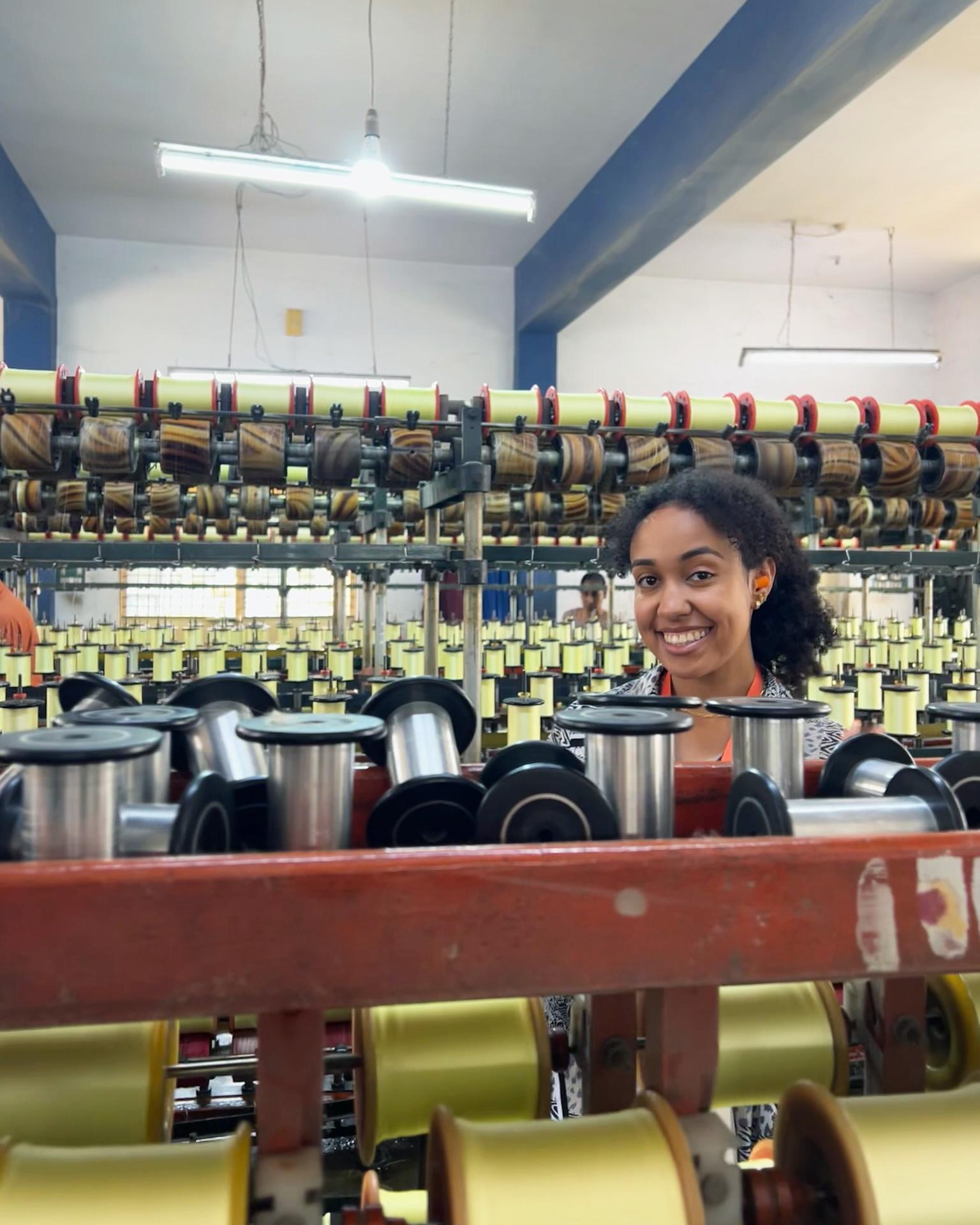 Imani Bodet stands in a thread production line