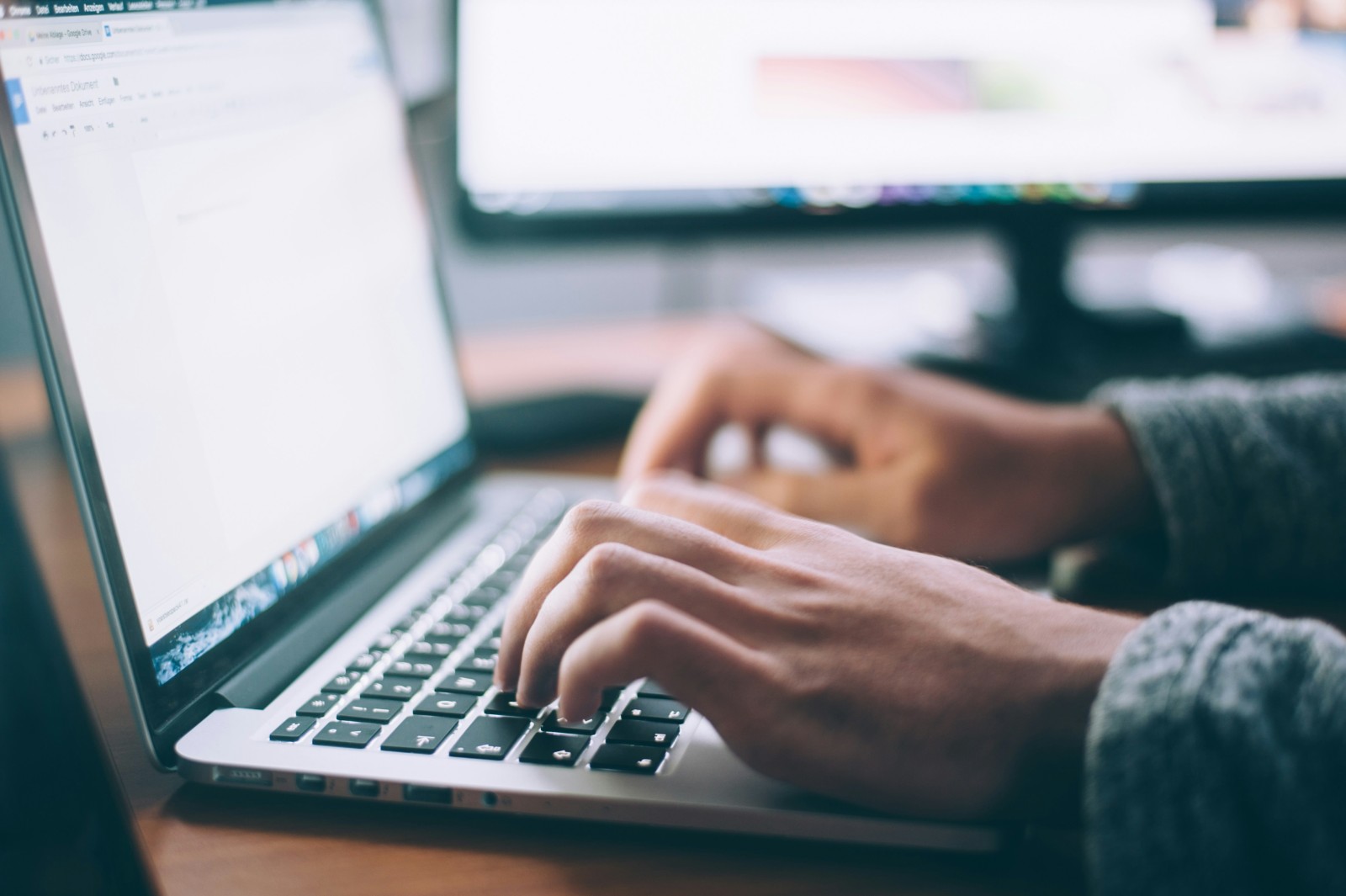 two hands touching a laptop keyboard