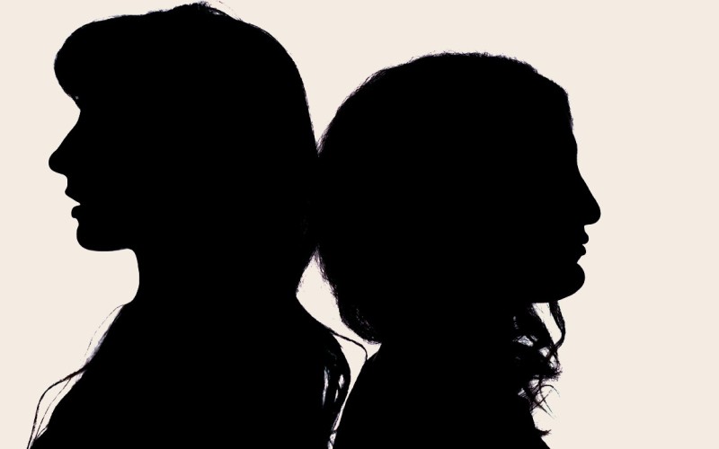 two silhouetted heads of people standing back to back