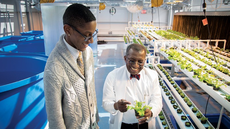 Philson Warner works with Teishawn W. Florostal Kevelier on growing lettuce on NYC school rooftop