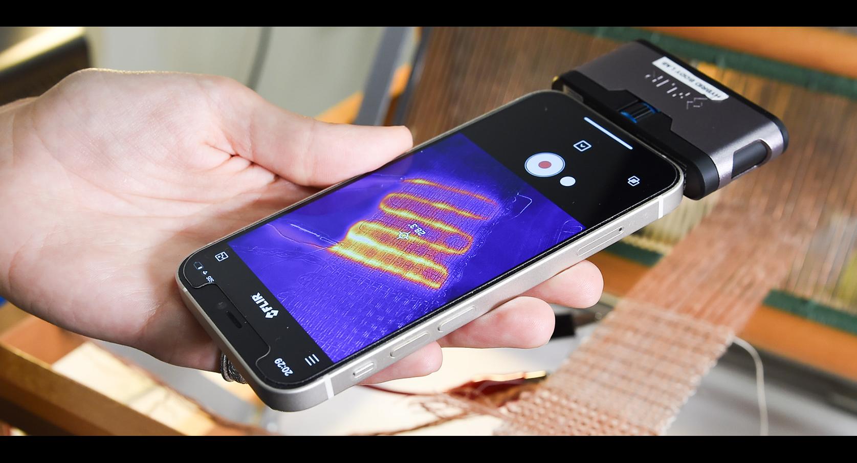 A phone controls temperature for a woven pocket-heater.