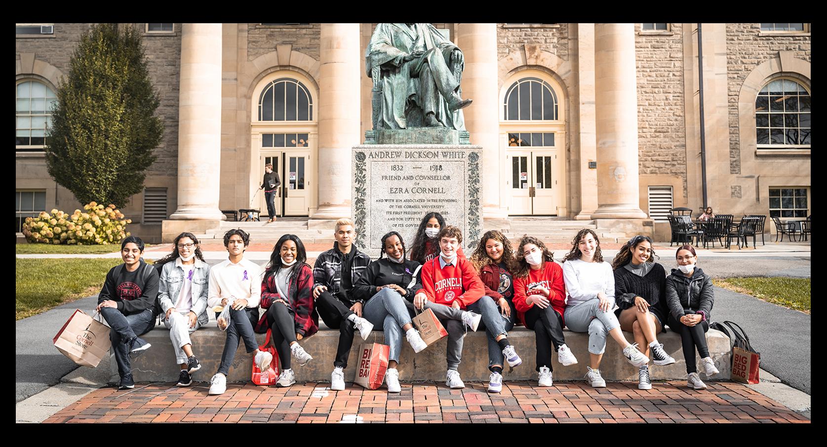 students sitting in a row mimicking a statue's pose