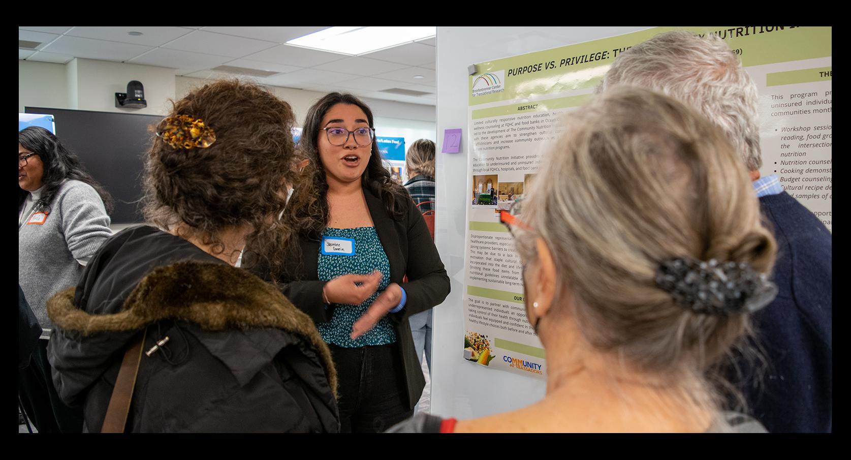 Jasmine Guarin ’24 speaks with attendees at an event.