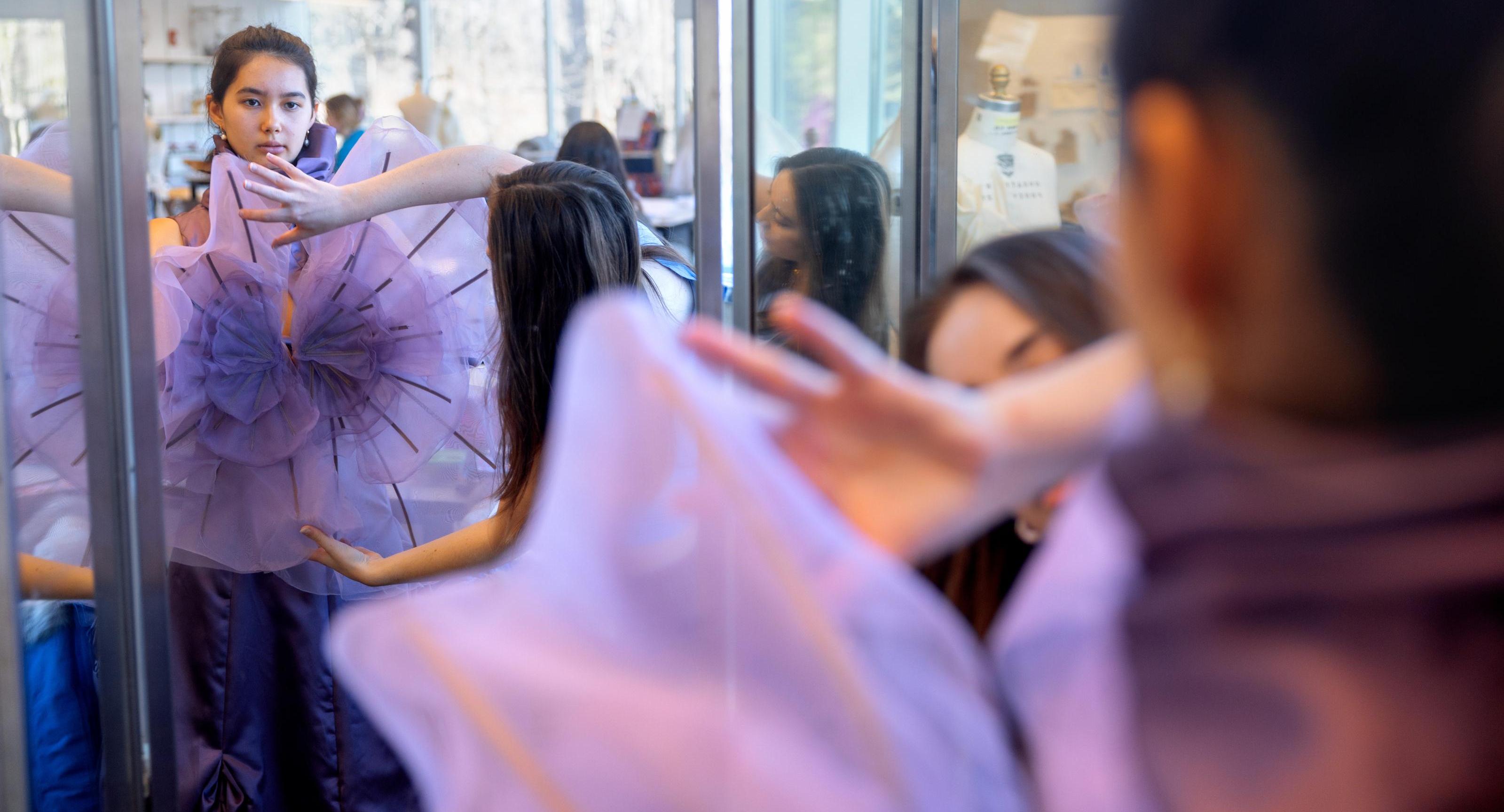 fitting a model in a purple outfit in a fashion studio
