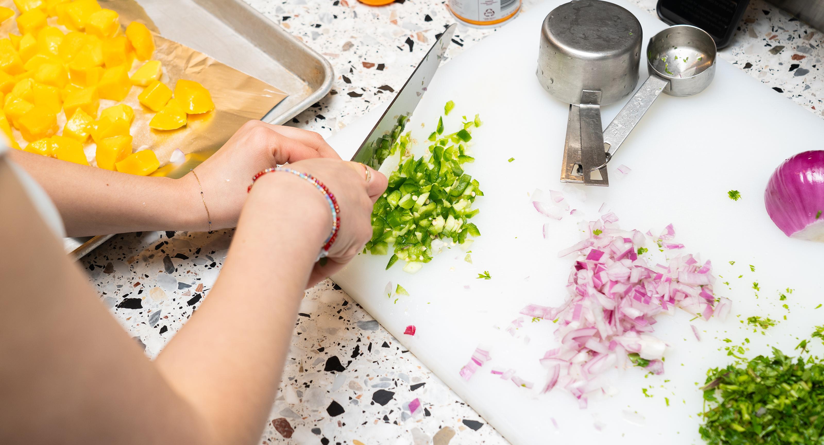 hands chopping vegetables in a kitchen