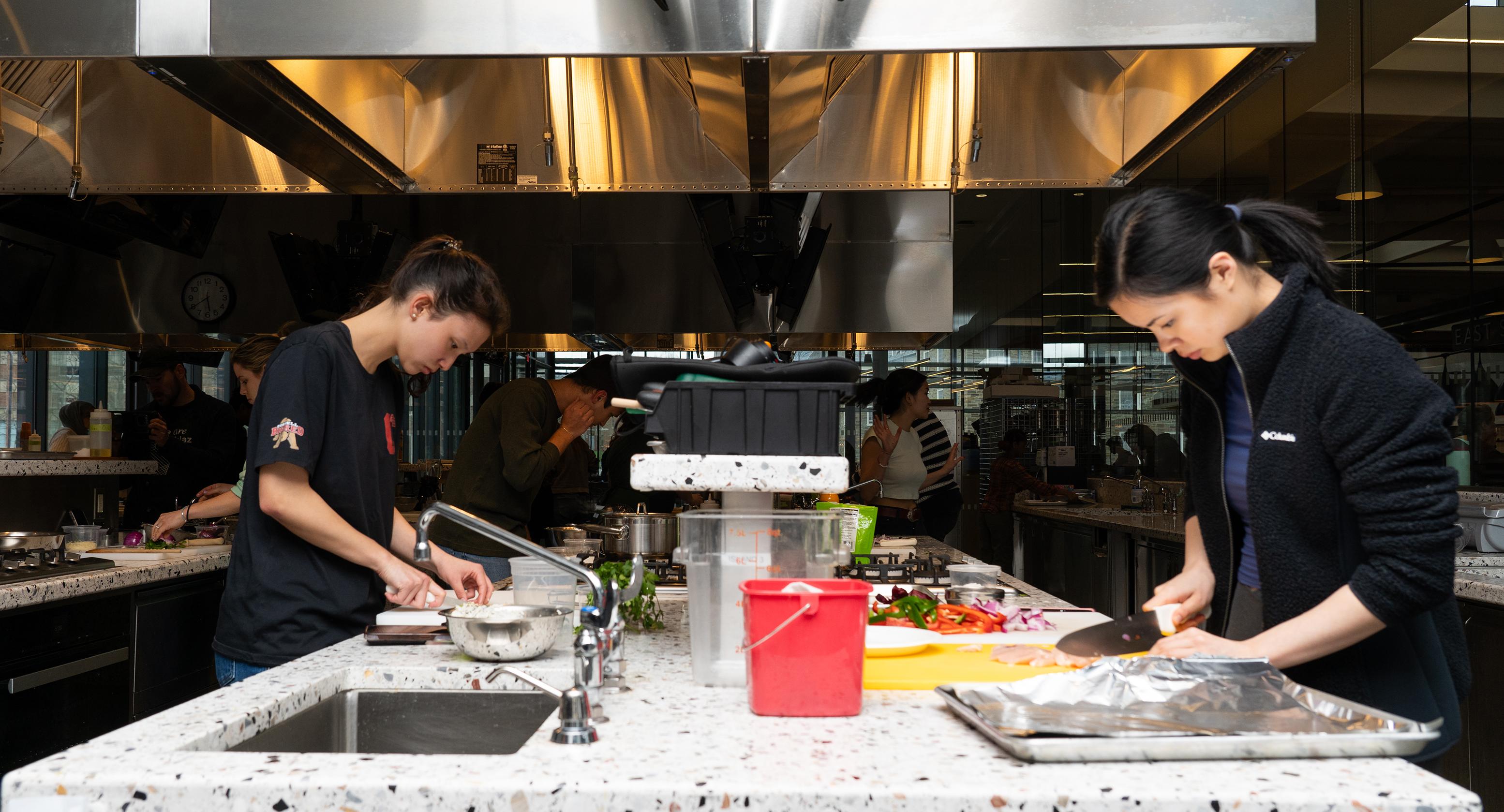 two students working in a teaching kitchen