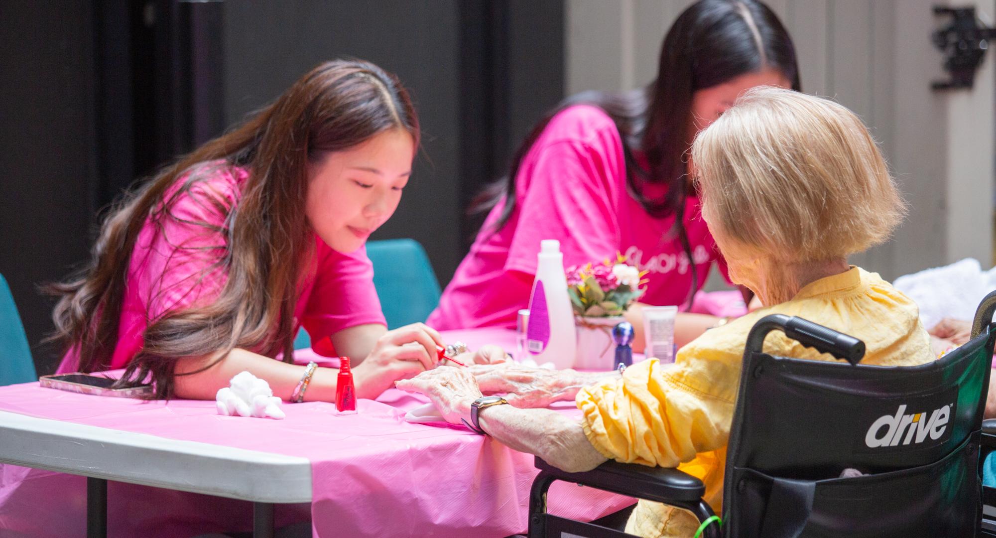 A volunteer paints a woman's nails in NYC 