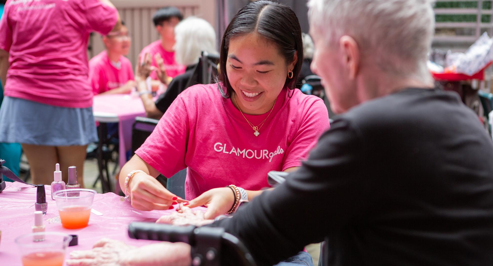 A student paints a woman's nails in NYC 