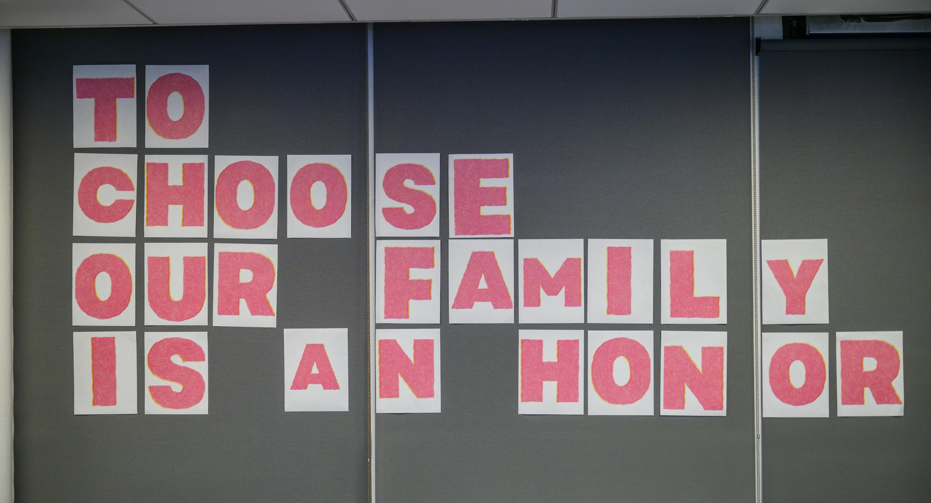 An art piece representing chosen families, displayed letter by letter to read "To choose our family is an honor."