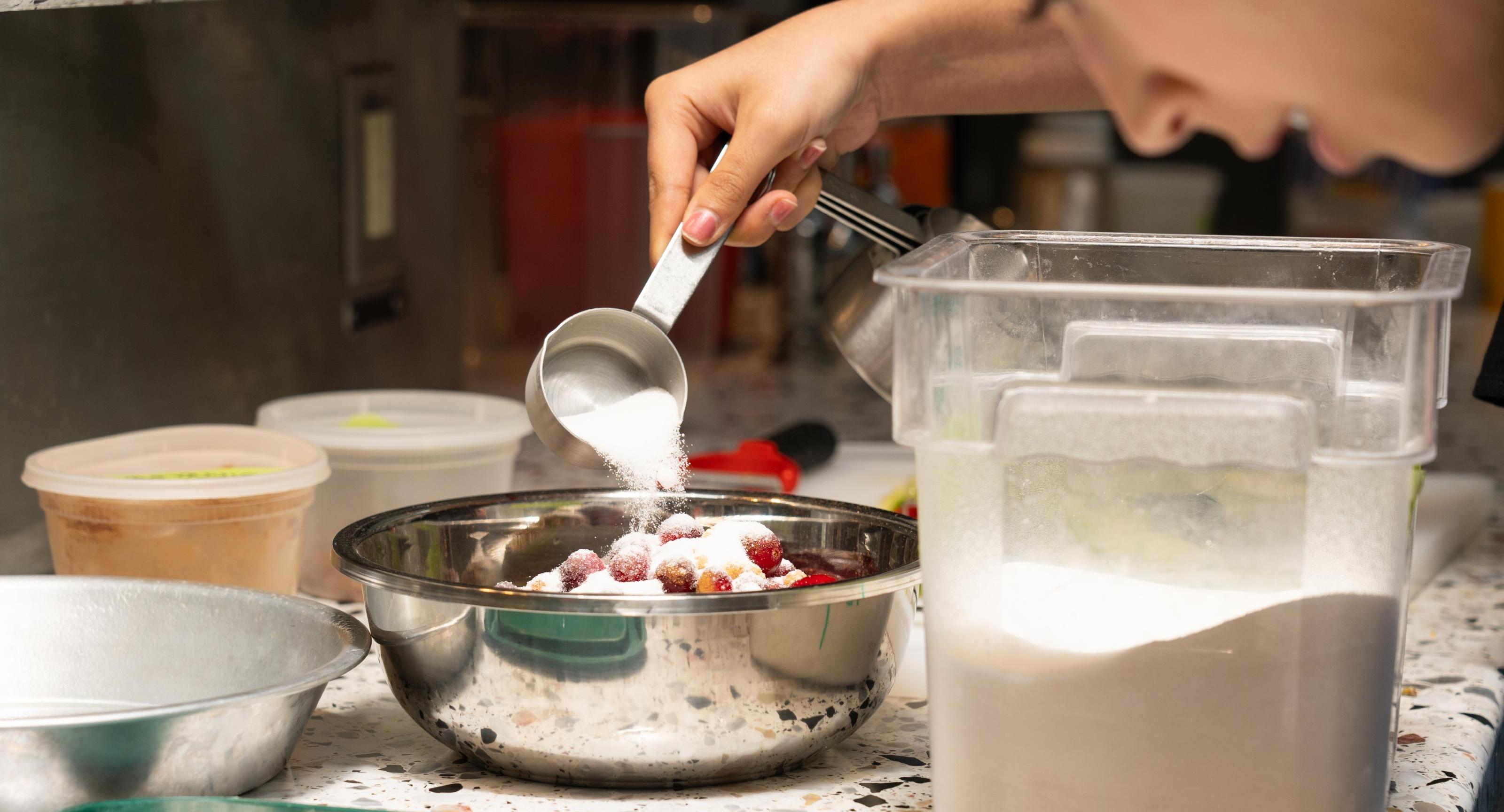 A student measuring flour in the Discovery Kitchen 