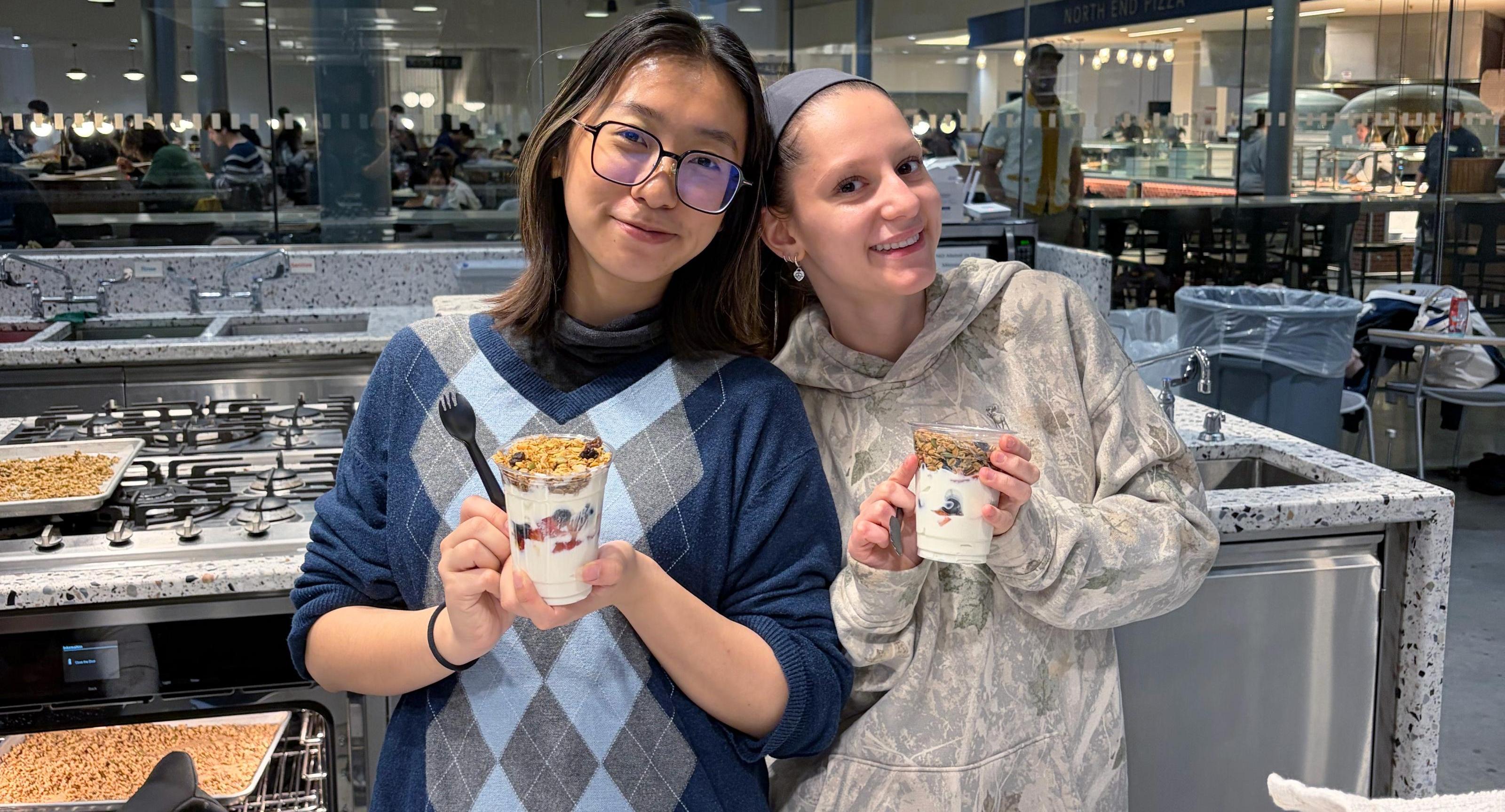 Two women hold yogert parfaits