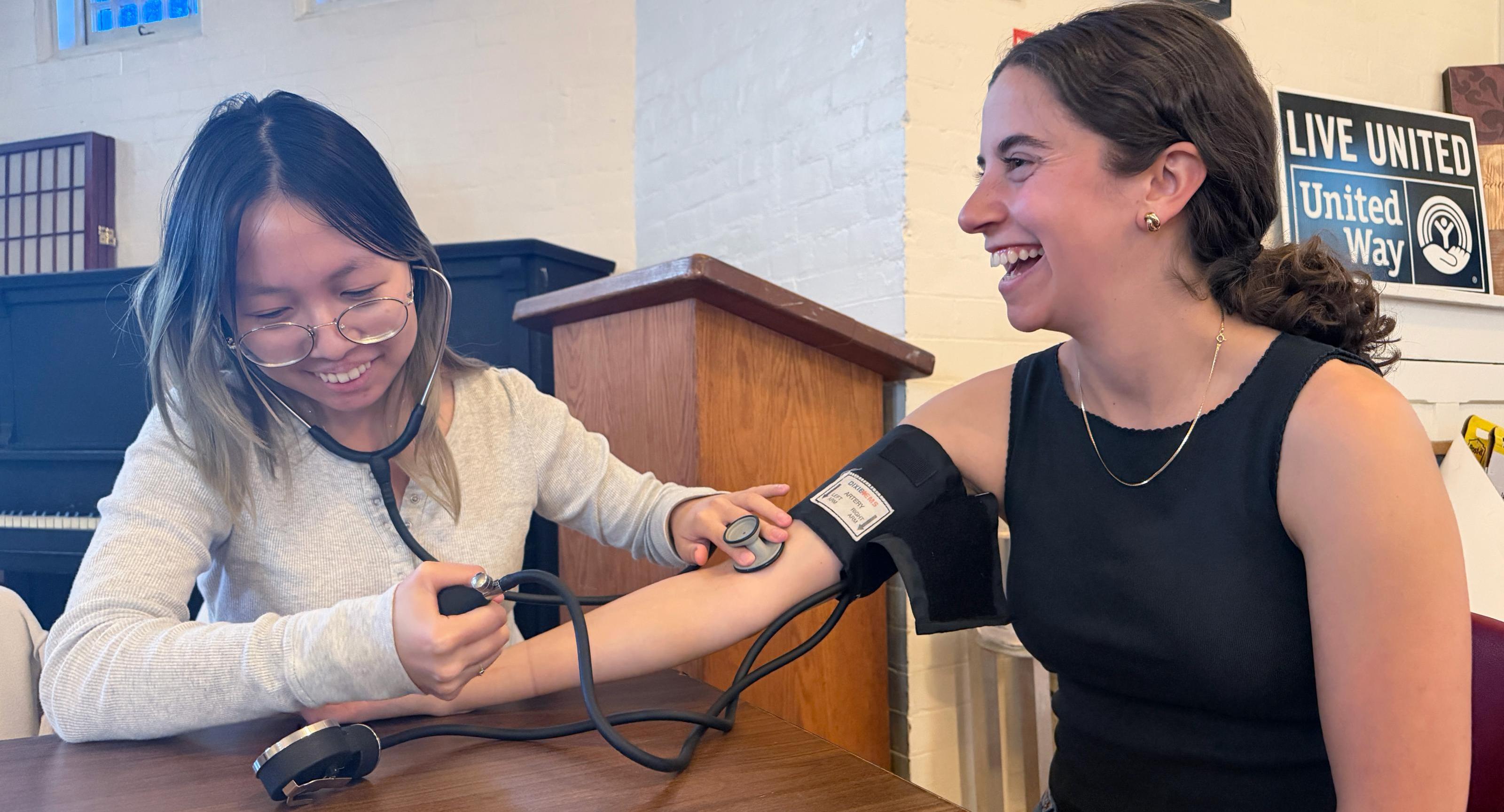 A woman takes the blood pressure of another woman