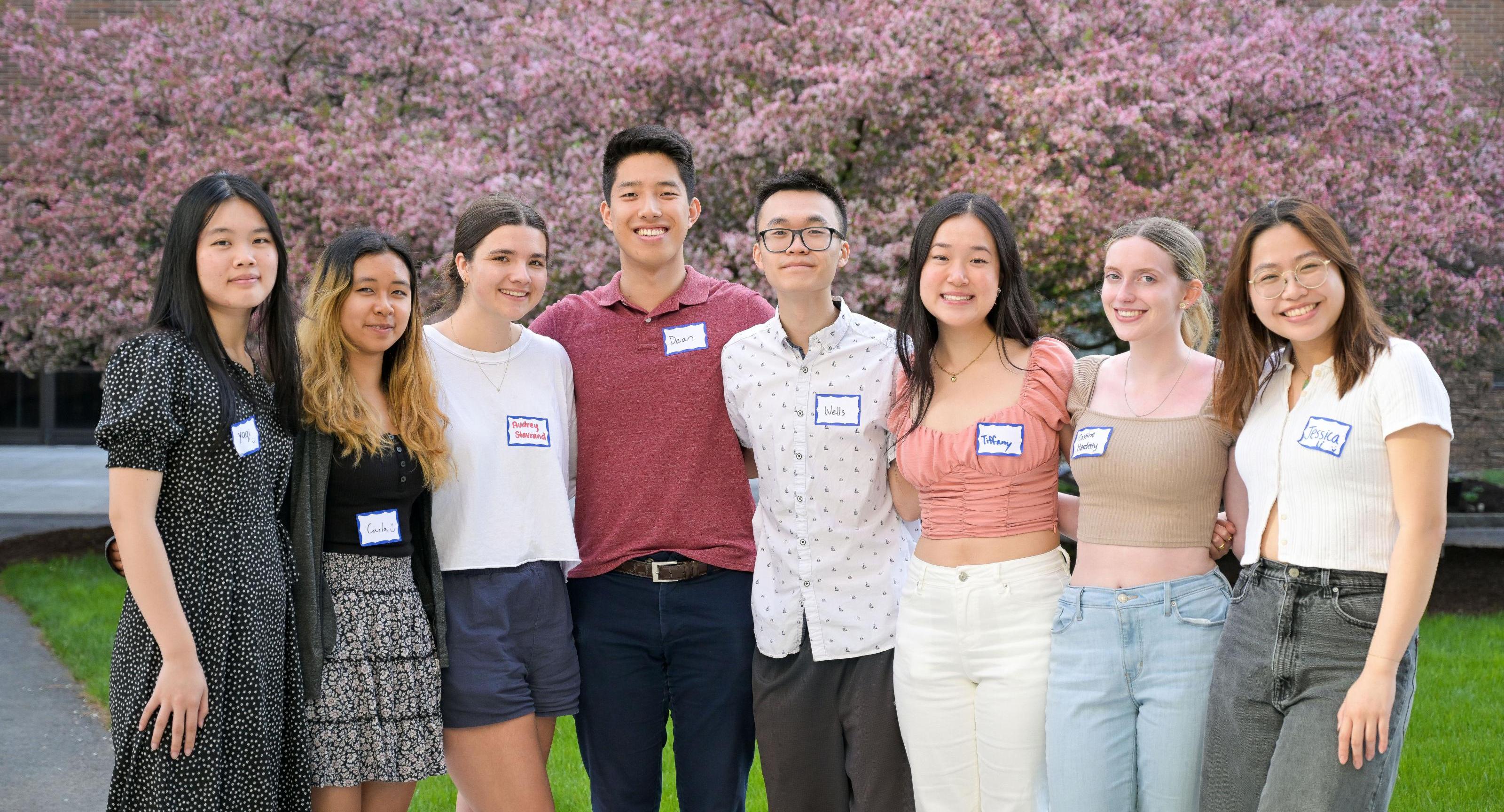 Wells Lee with friends in front of cherry blossom trees. 