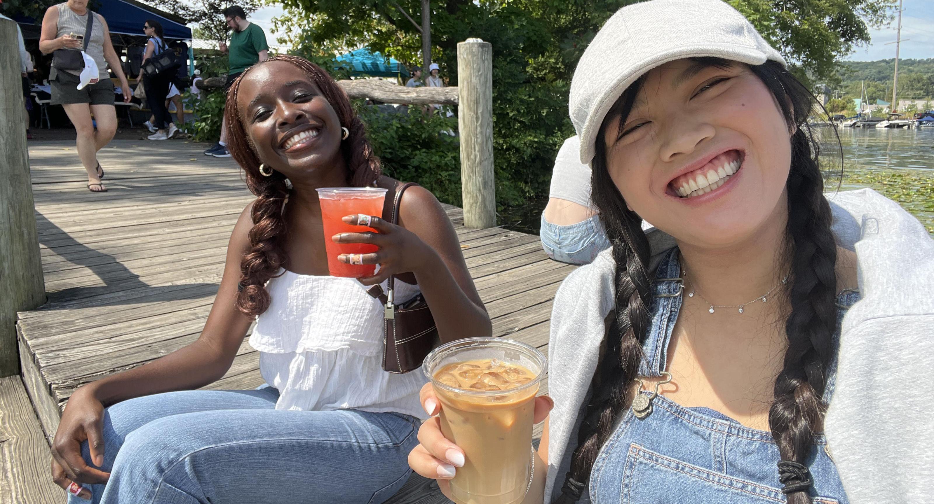 Oore with a friend sitting on a dock 