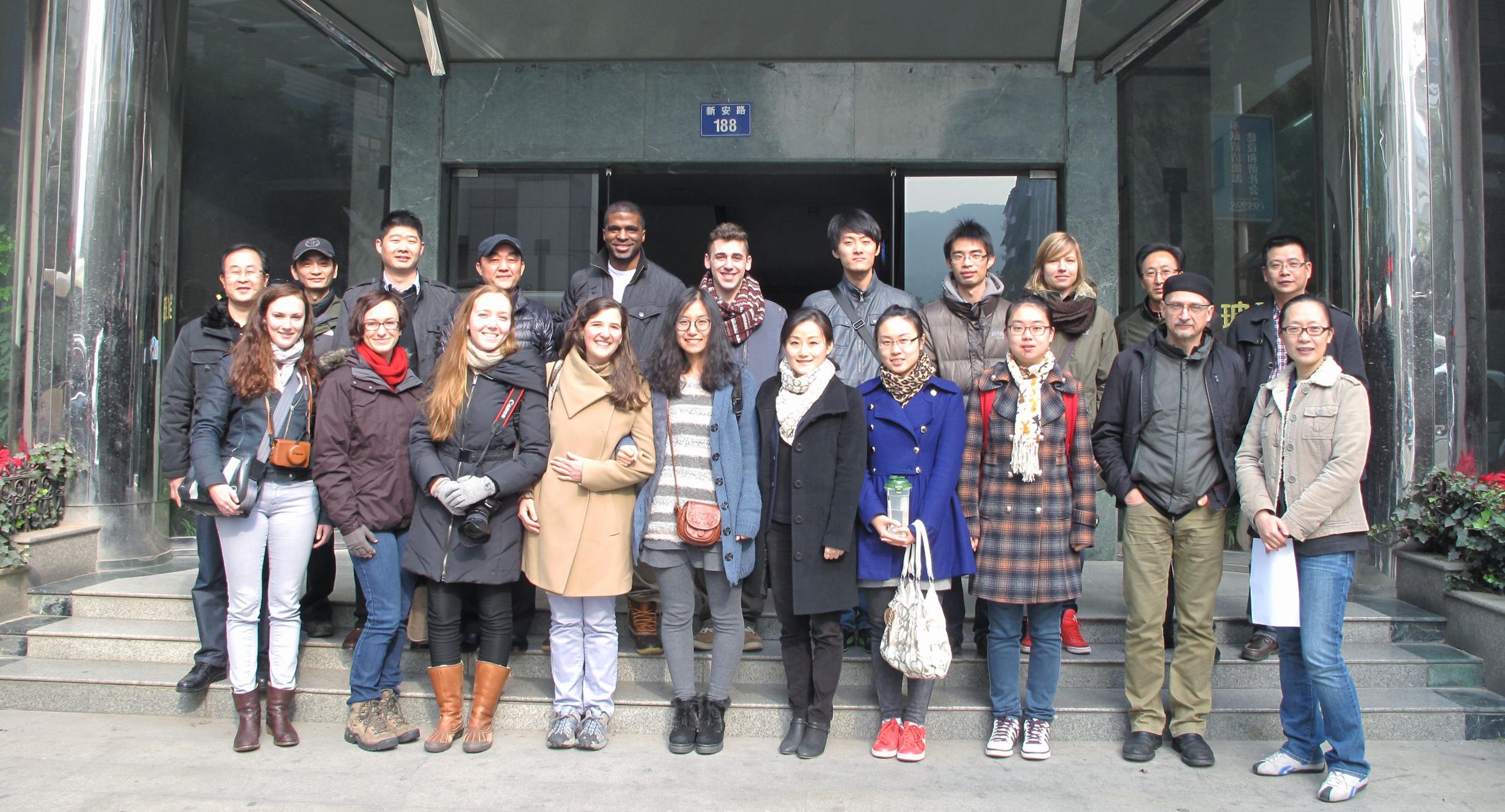 Group of 20+ people stand on steps of building in China.