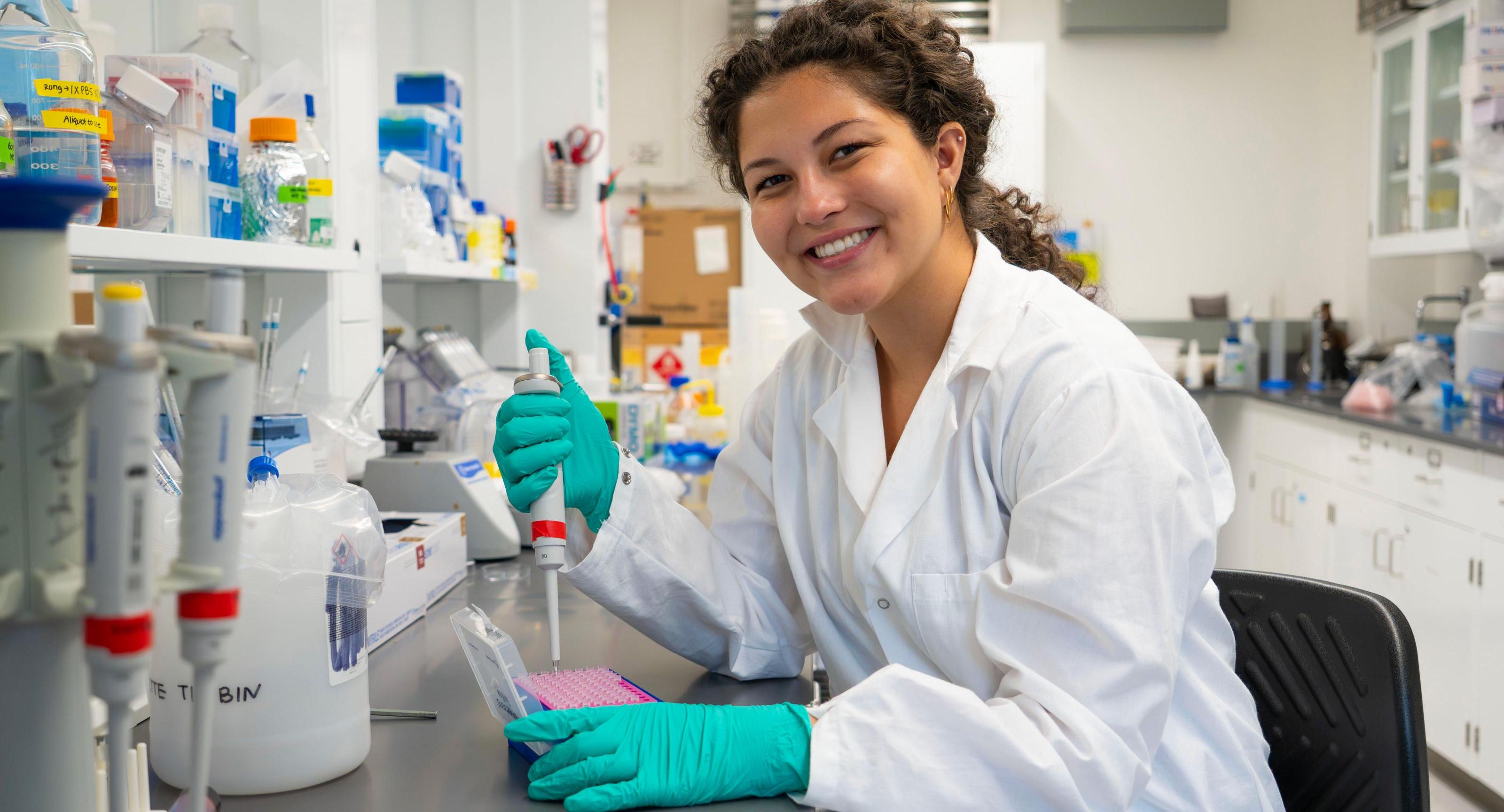 Angelina Mejia uses a pipette in the lab.