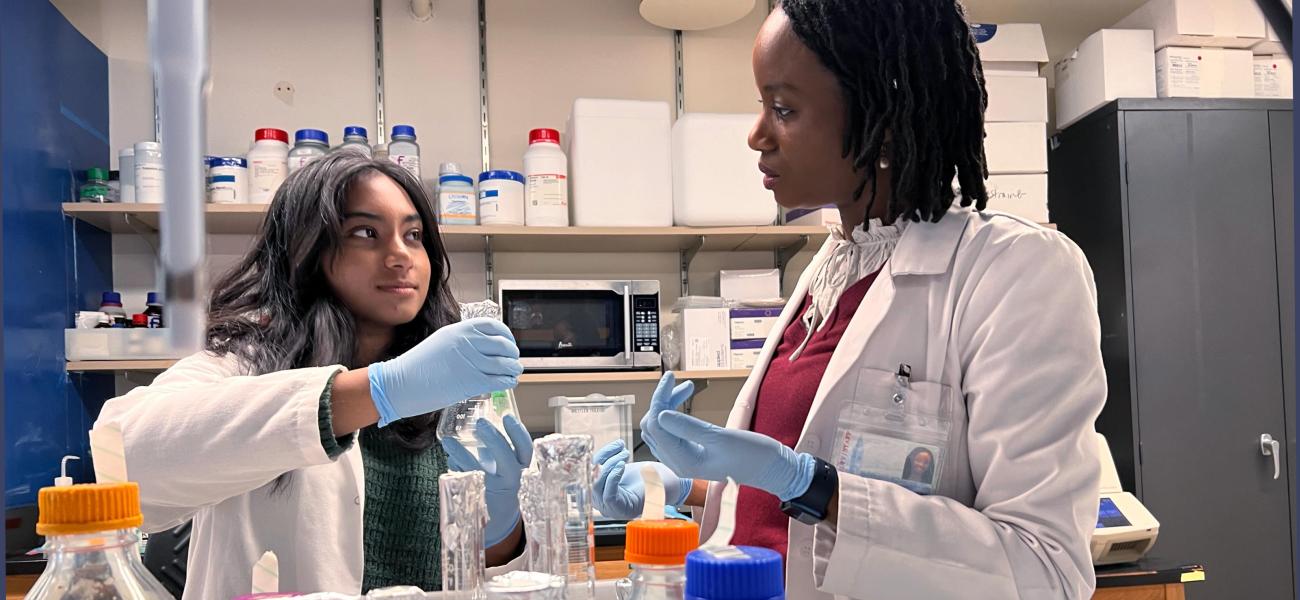 Joeva Barrow speaks with a student in her lab