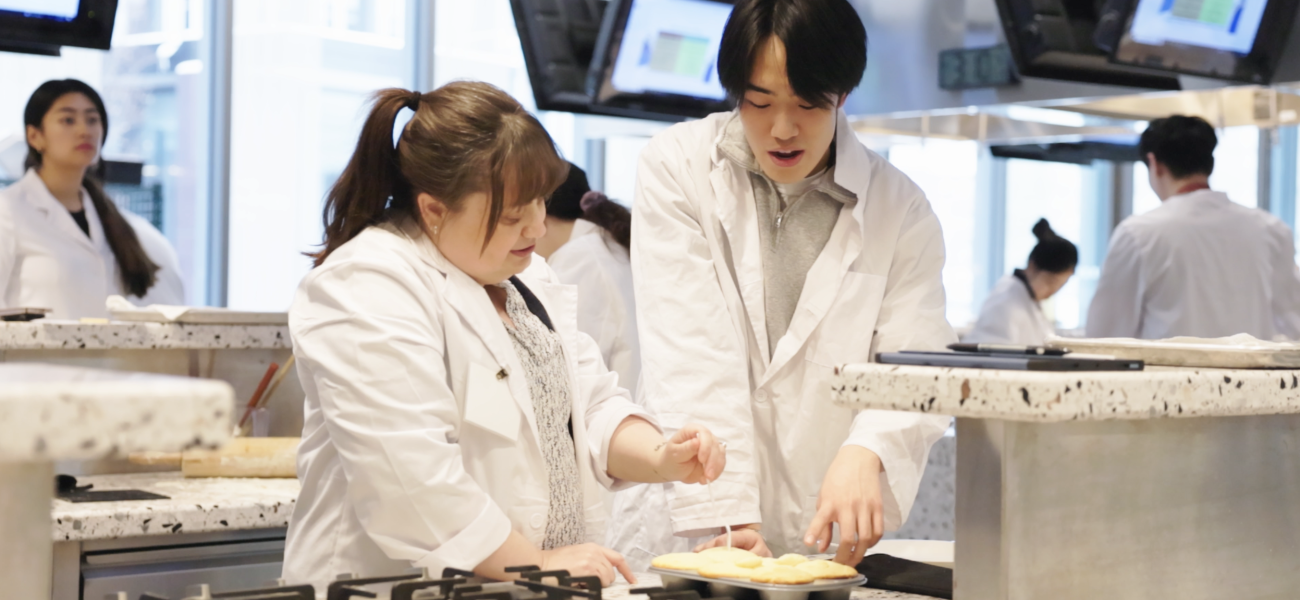 Erin Green examining muffins with a student in the Discovery Kitchen