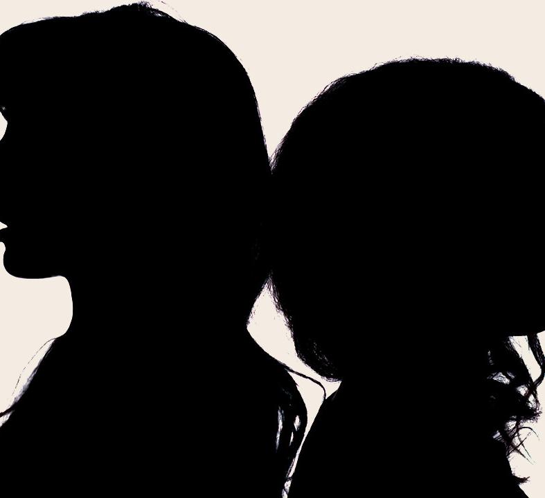 two silhouetted heads of people standing back to back