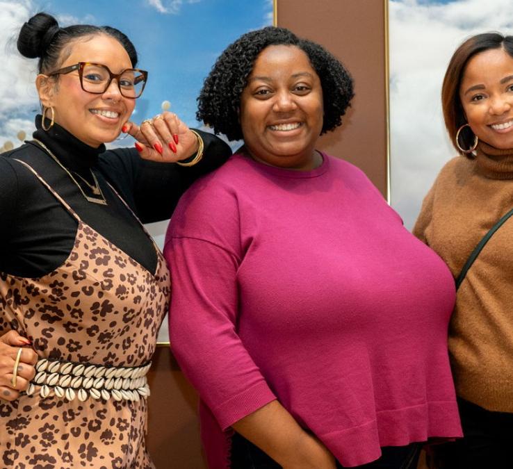 three people smiling at the camera