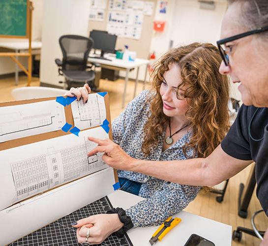 Student and faculty member looking at drawing