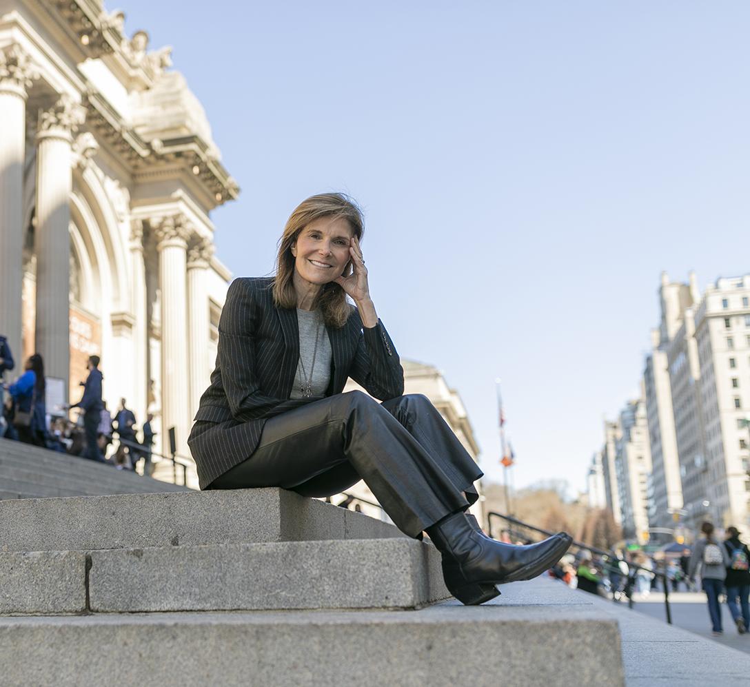woman sitting on the steps of The Metropolitan Museum of Art in NYC