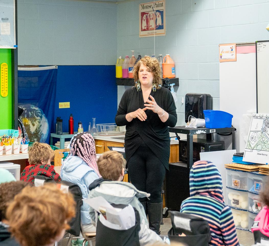 woman standing in front of a fourth grade classroom