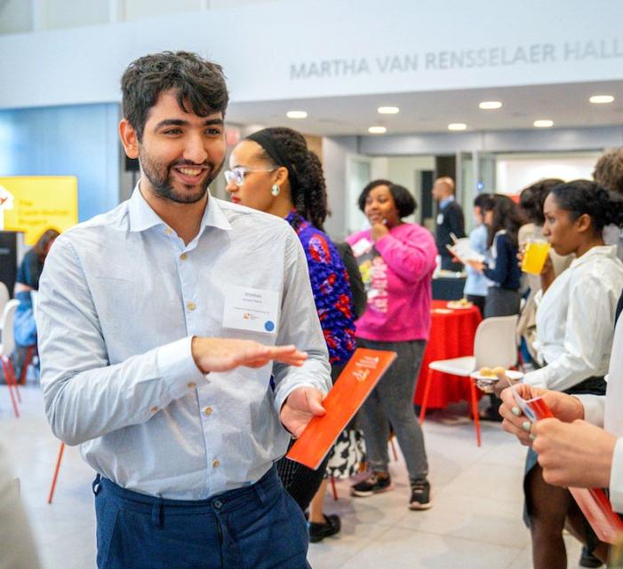 A student explains his project to peers