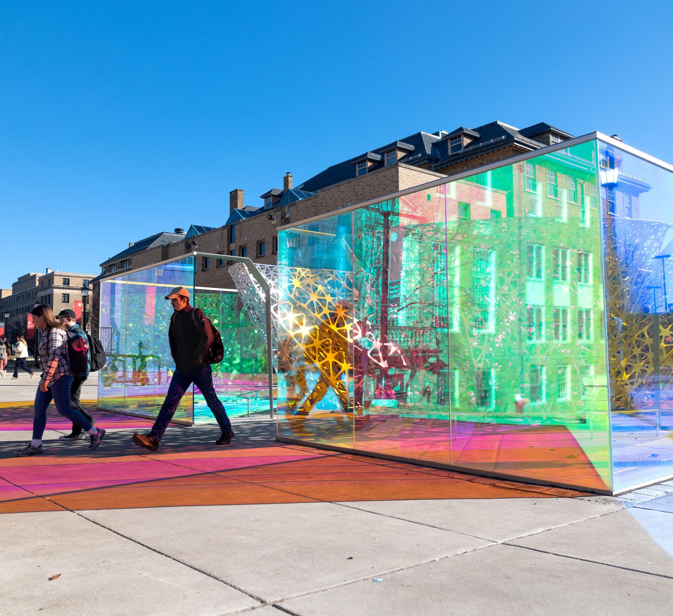 a faculty member walks past the polyform sculpture
