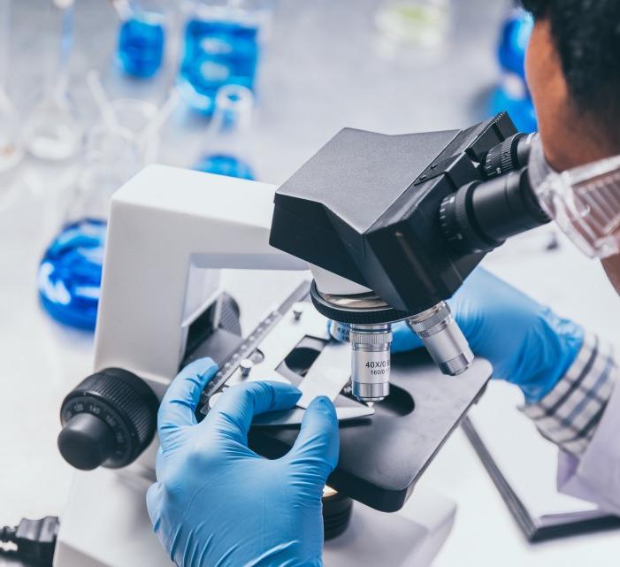 Image of a male-presenting person looking in a microscope